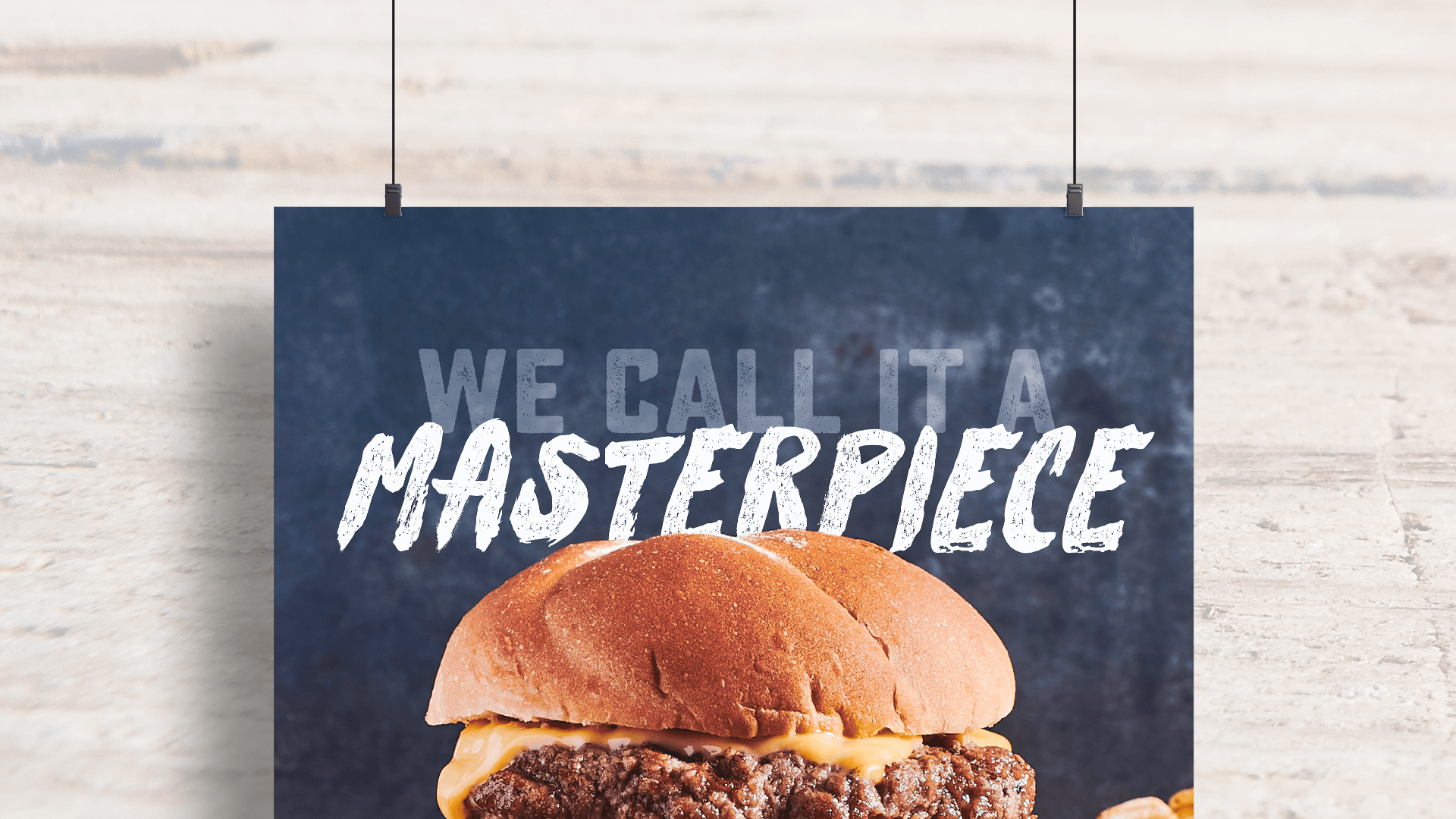 Poster with text that readys "We call it a masterpiece" and a burger image